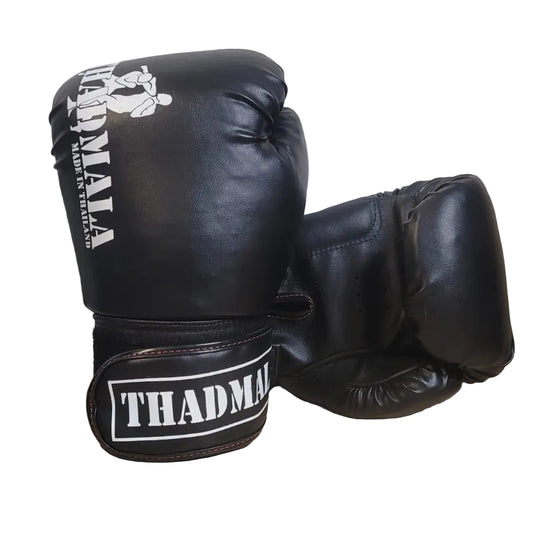 Black boxing gloves with 'THADMA' branding on a wooden surface.