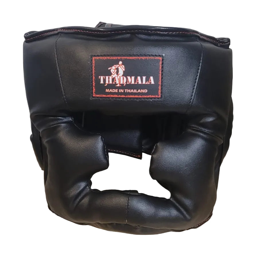 Black boxing headgear with a brand logo on a wooden surface