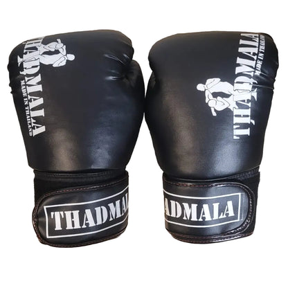 Pair of black boxing gloves with white text on a wooden surface, with a person's feet visible in the background.