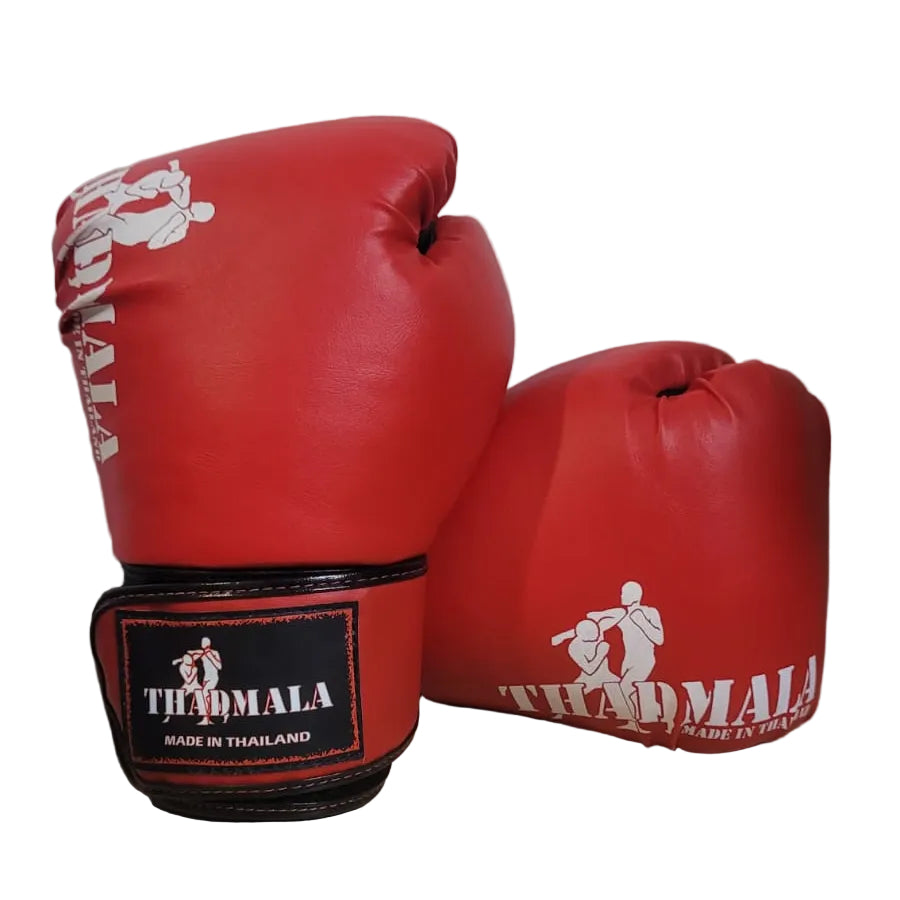 Red boxing gloves with 'Thailand' branding on a wooden surface.