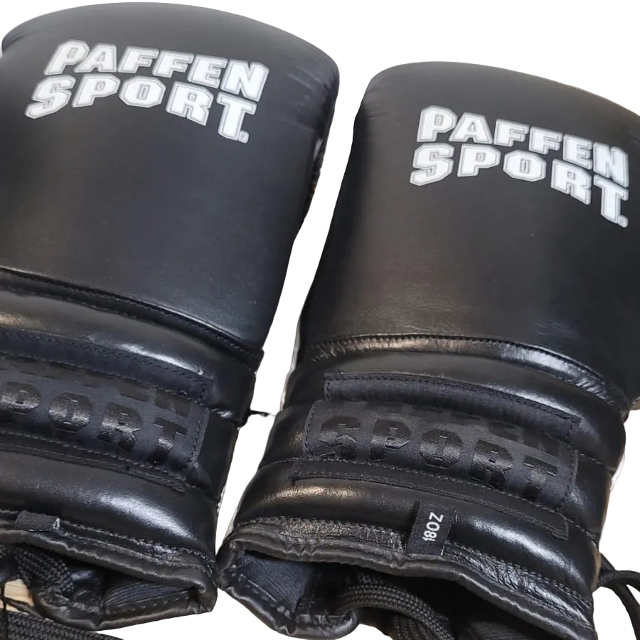 Pair of black boxing gloves with 'PAFFEN SPORT' branding on a wooden surface.